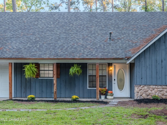 exterior space featuring a porch, a garage, and a lawn