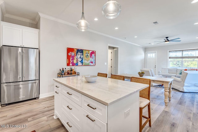 kitchen featuring a center island, high end refrigerator, white cabinets, and light hardwood / wood-style floors