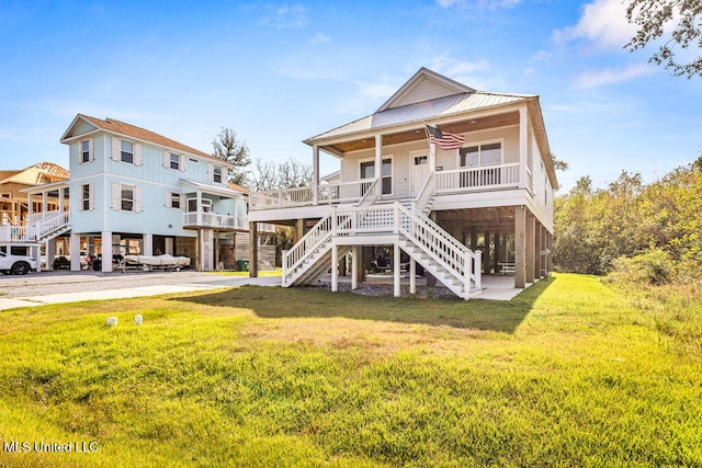 back of house featuring a porch, a carport, a lawn, and ceiling fan