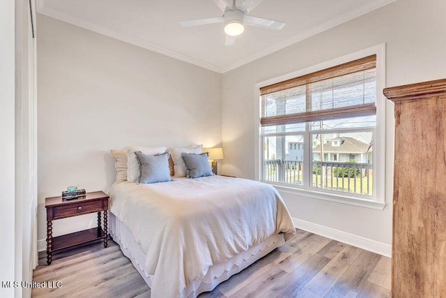 bedroom featuring ceiling fan, ornamental molding, and light hardwood / wood-style flooring