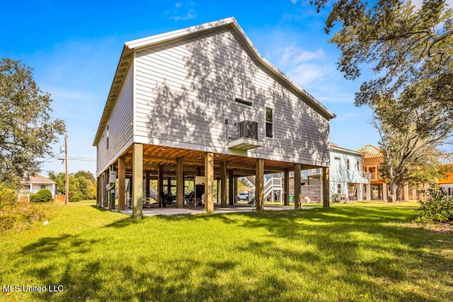 back of house featuring a yard, a carport, and a patio