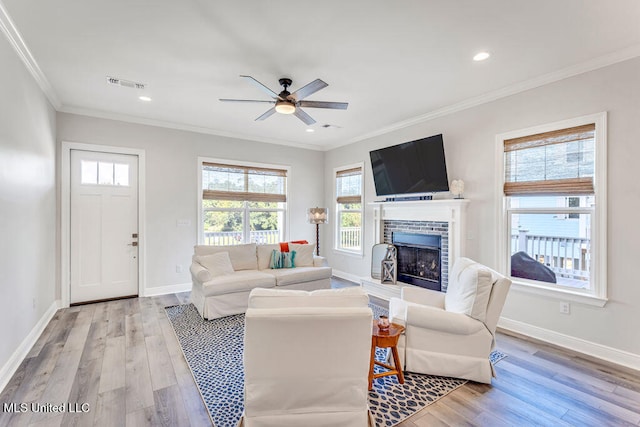 living room featuring crown molding, light hardwood / wood-style floors, and ceiling fan