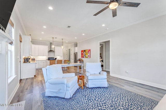 living room with light hardwood / wood-style floors, crown molding, and ceiling fan