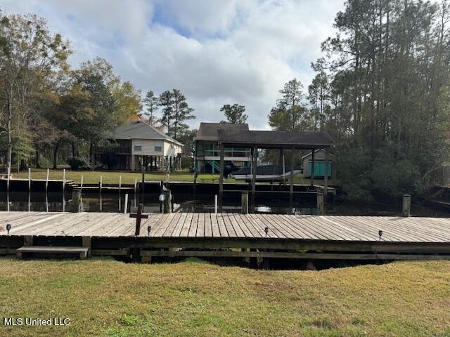 view of dock featuring a lawn and a water view