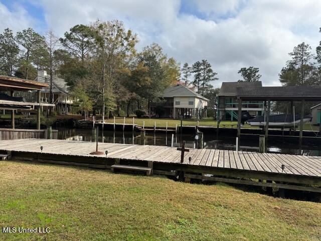 view of dock featuring a lawn and a water view