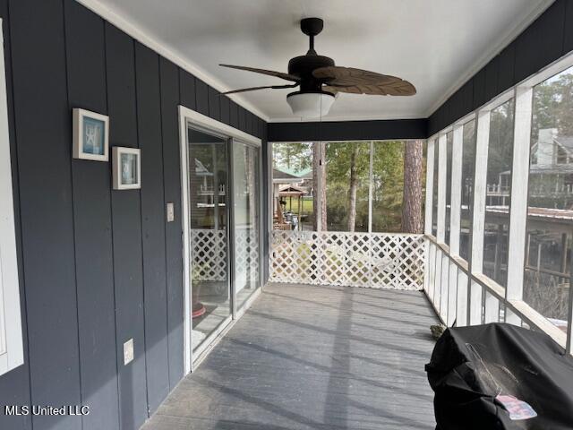 unfurnished sunroom with a wealth of natural light and ceiling fan