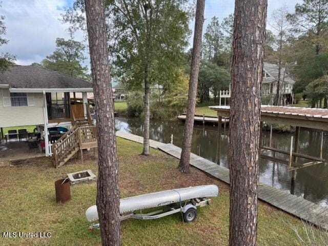 view of dock with a lawn and a water view