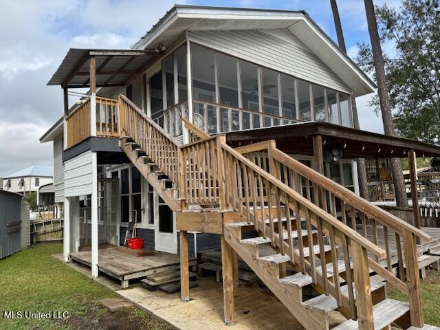 rear view of property with a wooden deck and a sunroom