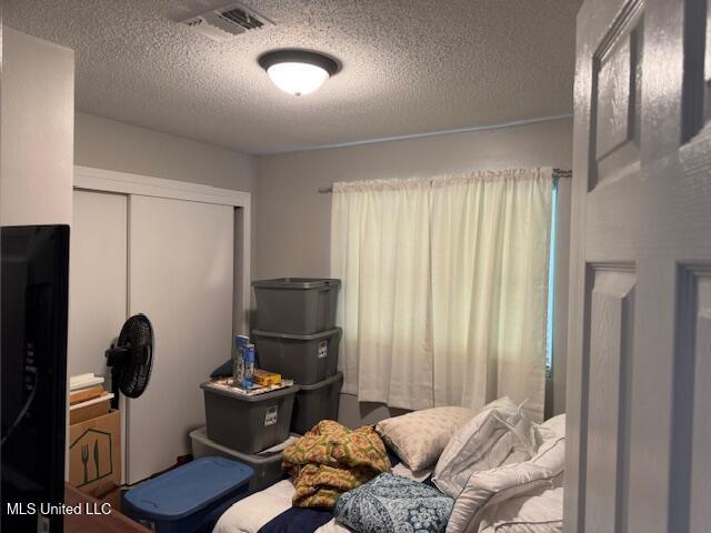 bedroom with a closet and a textured ceiling