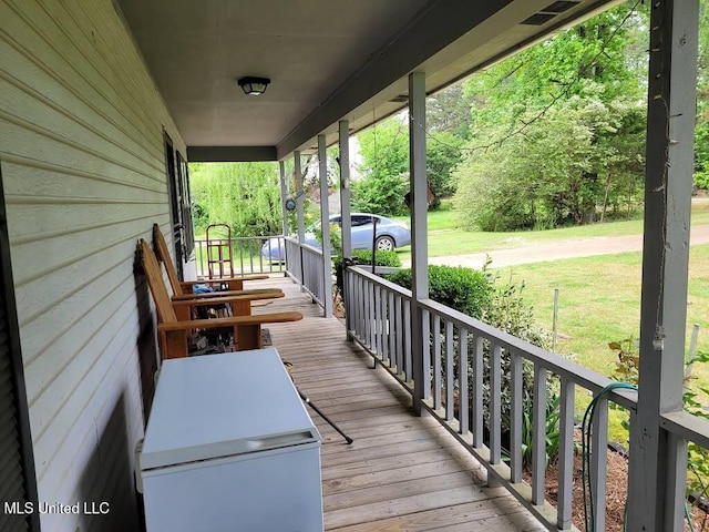 deck with covered porch and a yard