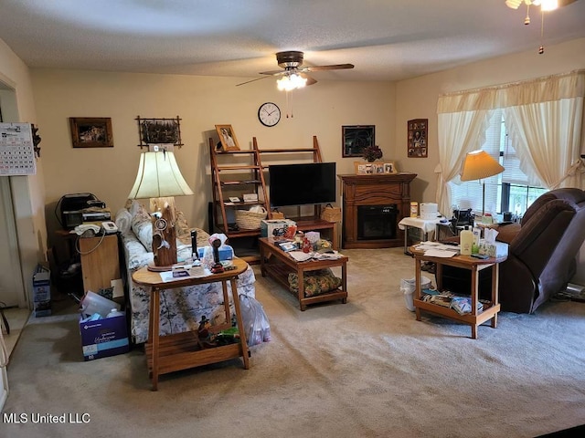 carpeted living area featuring a ceiling fan and a fireplace