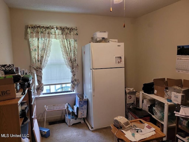 kitchen featuring freestanding refrigerator and carpet flooring