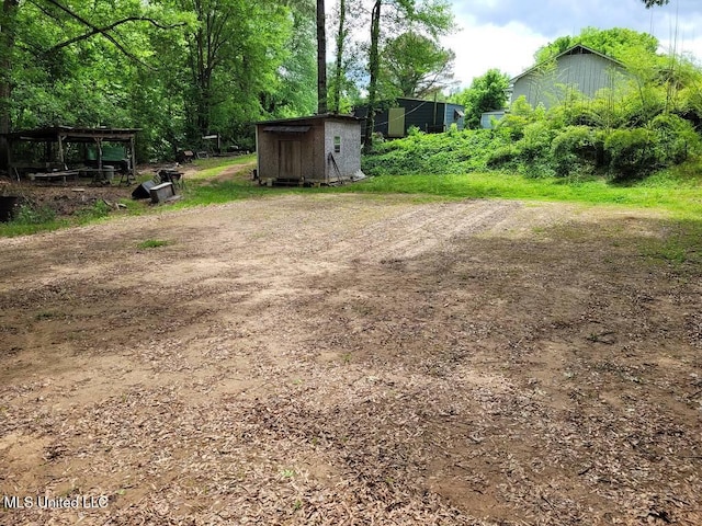 view of yard featuring a storage shed and an outbuilding