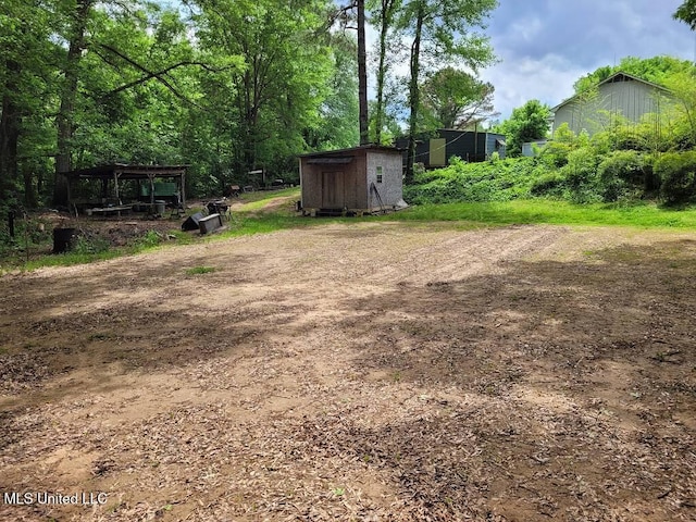 view of yard featuring an outdoor structure and a shed