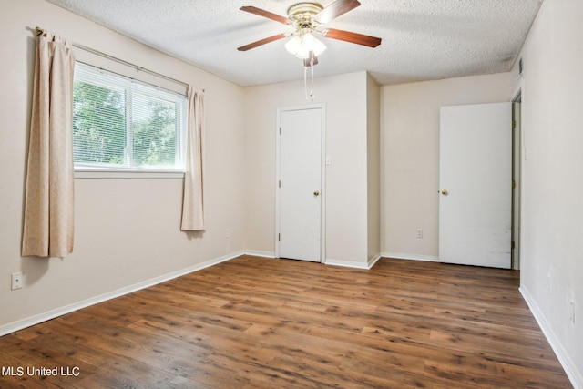 unfurnished bedroom featuring ceiling fan, a textured ceiling, and dark hardwood / wood-style floors