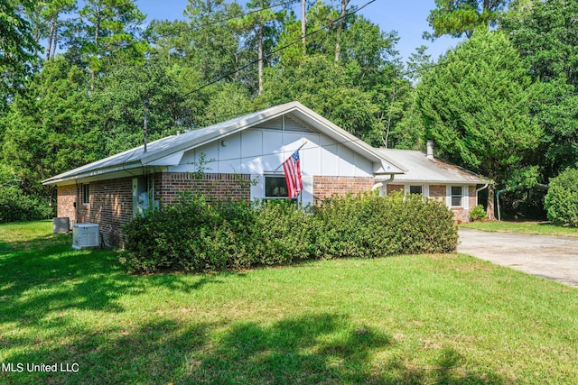 view of property exterior with a yard and central AC unit