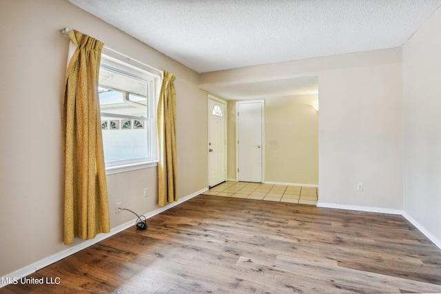 spare room featuring hardwood / wood-style floors and a textured ceiling