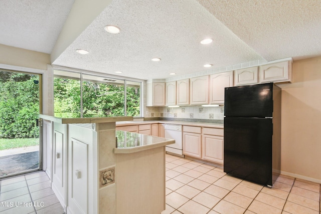 kitchen featuring black refrigerator, white dishwasher, light tile patterned floors, a textured ceiling, and tasteful backsplash