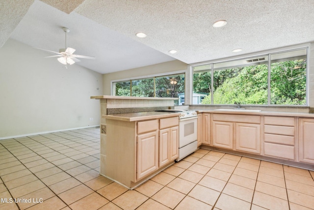 kitchen featuring light tile patterned flooring, light brown cabinetry, sink, and white range