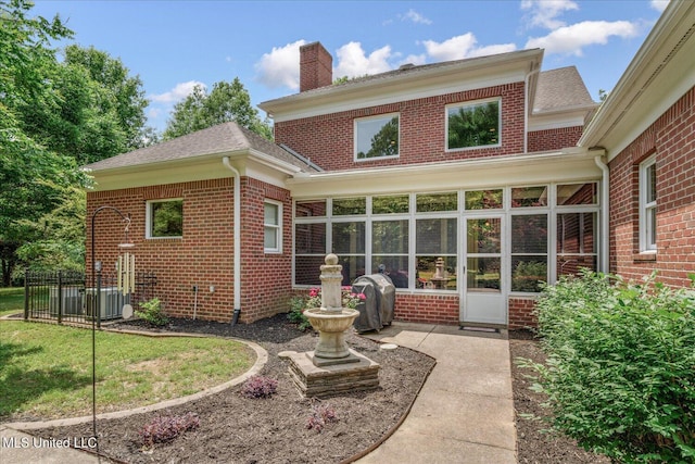5264 Chappel Cv, Olive Branch, MS 38654 - rear view of house featuring a sunroom, brick siding, a chimney, and a shingled roof