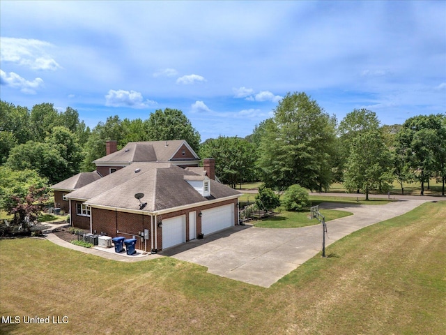 5264 Chappel Cv, Olive Branch, MS 38654 - view of side of home featuring concrete driveway, a lawn, a garage, a chimney, and roof with shingles