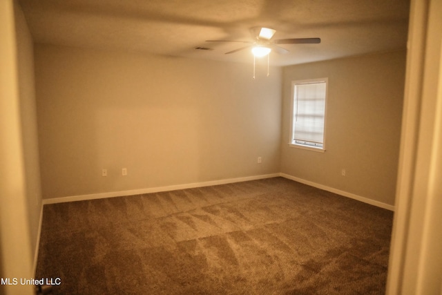 empty room featuring ceiling fan and dark carpet