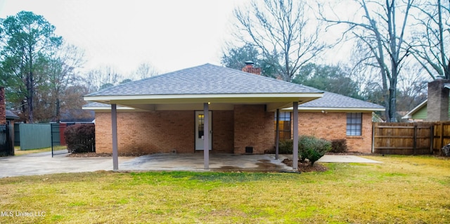 rear view of house with a patio and a lawn