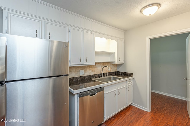 kitchen featuring stainless steel appliances, sink, decorative backsplash, and white cabinets