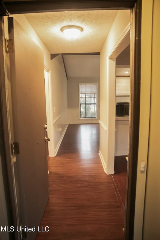 hallway featuring dark wood-type flooring and a textured ceiling