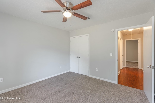 unfurnished bedroom with ceiling fan, a closet, carpet flooring, and a textured ceiling