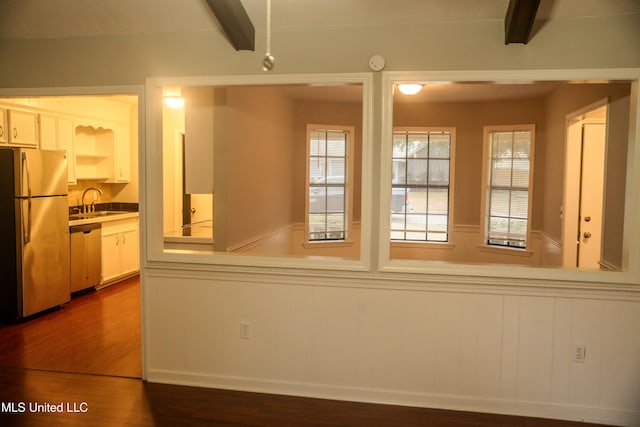 spare room with dark hardwood / wood-style floors, sink, and beam ceiling