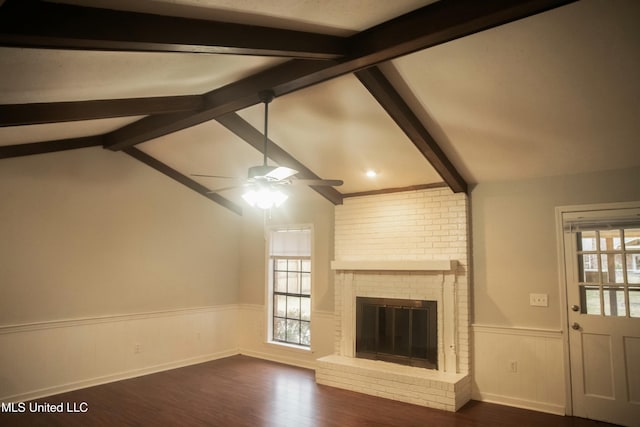 unfurnished living room featuring a brick fireplace, dark wood-type flooring, lofted ceiling with beams, and ceiling fan