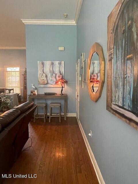 corridor featuring ornamental molding and dark hardwood / wood-style flooring