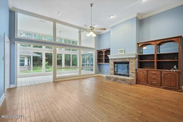 7828 Loa Pl, Diamondhead, MS 39525 - unfurnished living room featuring ornamental molding, a healthy amount of sunlight, ceiling fan, a towering ceiling, and hardwood / wood-style flooring
