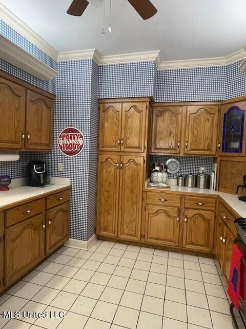 kitchen with crown molding, tasteful backsplash, stove, and ceiling fan