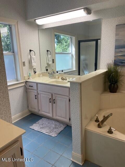 bathroom with vanity, plus walk in shower, and tile patterned flooring