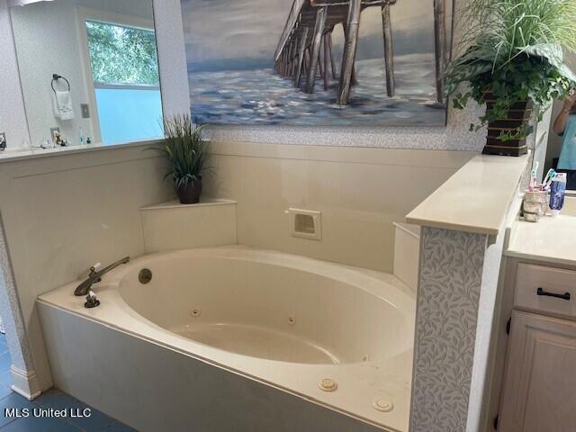 bathroom with vanity and a washtub