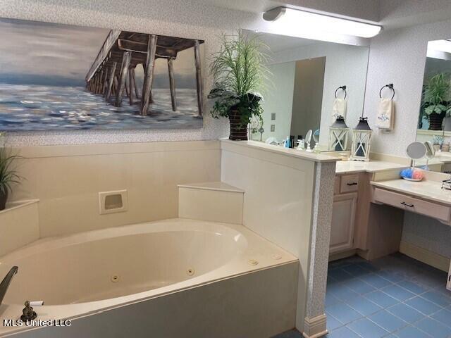 bathroom with vanity, a tub, and tile patterned floors