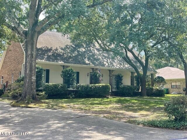 7828 Loa Pl, Diamondhead, MS 39525 - view of front of house with stucco siding and a front yard