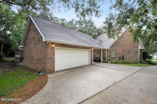 7828 Loa Pl, Diamondhead, MS 39525 - view of front facade featuring an attached garage, a shingled roof, brick siding, and driveway