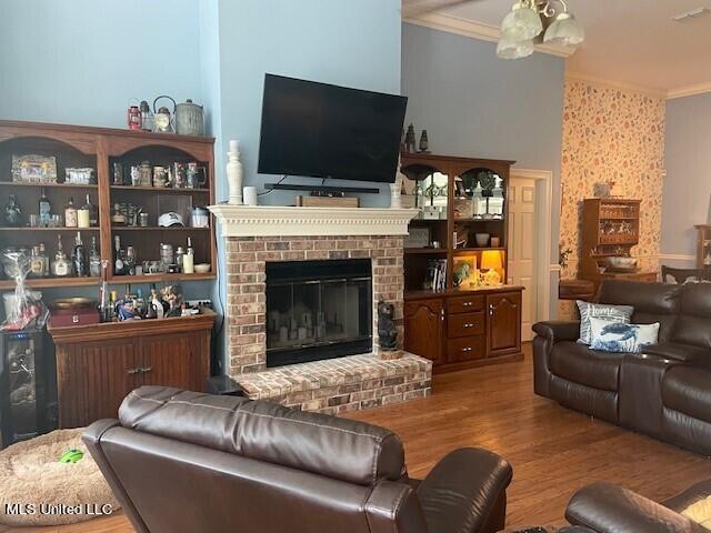 living room featuring crown molding, hardwood / wood-style flooring, and a fireplace