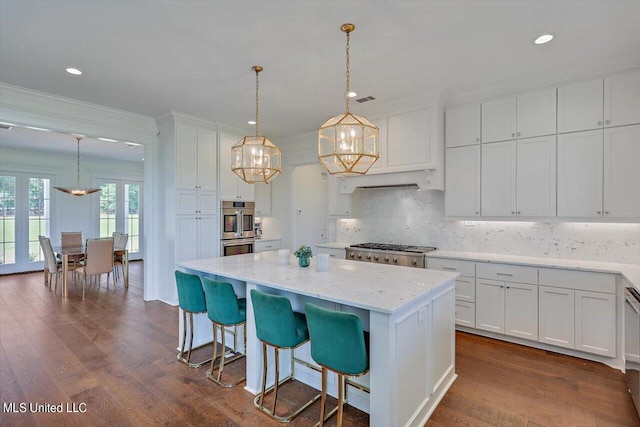 kitchen with white cabinetry, dark wood-type flooring, a center island, and pendant lighting