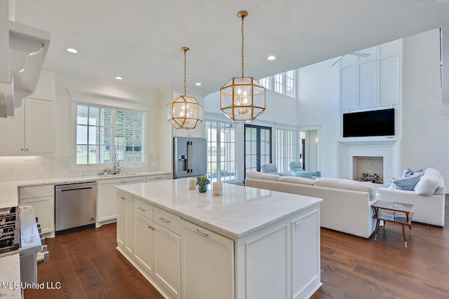 kitchen with dishwasher, a center island, dark hardwood / wood-style flooring, hanging light fixtures, and white cabinetry