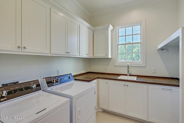 clothes washing area featuring light tile patterned flooring, sink, washer and clothes dryer, ornamental molding, and cabinets