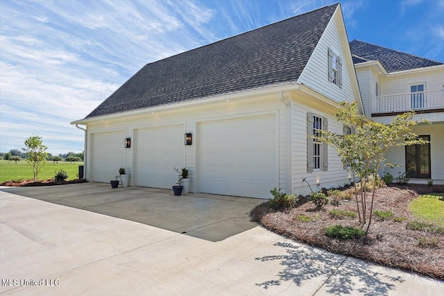 view of property exterior featuring a balcony and a garage