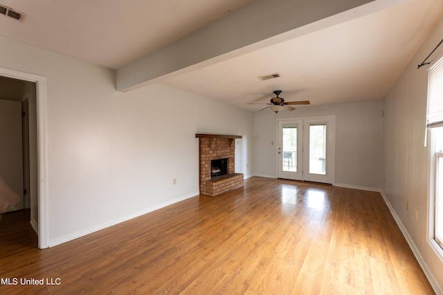 unfurnished living room featuring light hardwood / wood-style floors, vaulted ceiling with beams, a fireplace, and ceiling fan