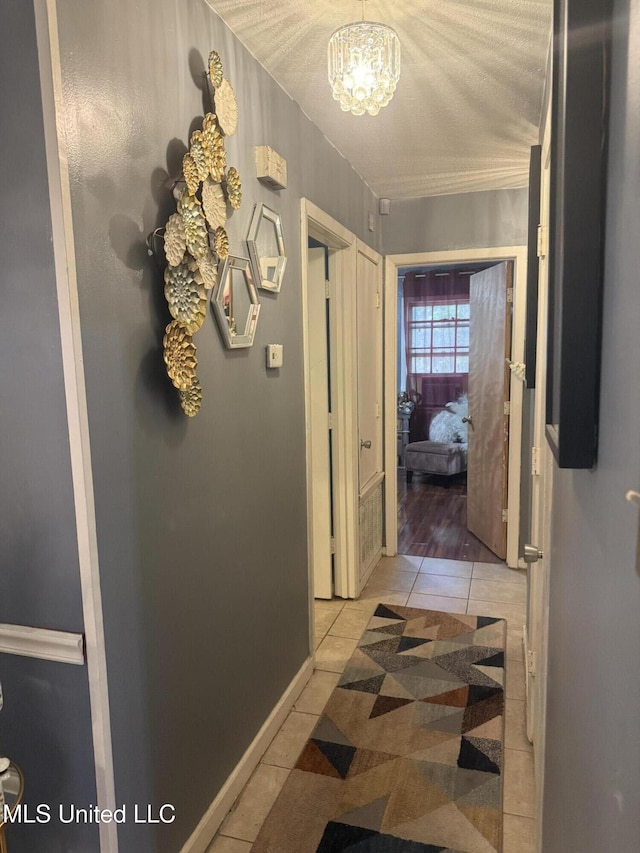 434 Boehle St, Pearl, MS 39208 - hallway featuring light tile patterned floors, a chandelier, and baseboards