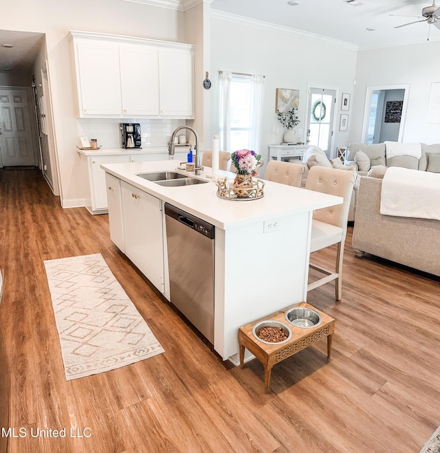 kitchen featuring open floor plan, a sink, backsplash, and stainless steel dishwasher