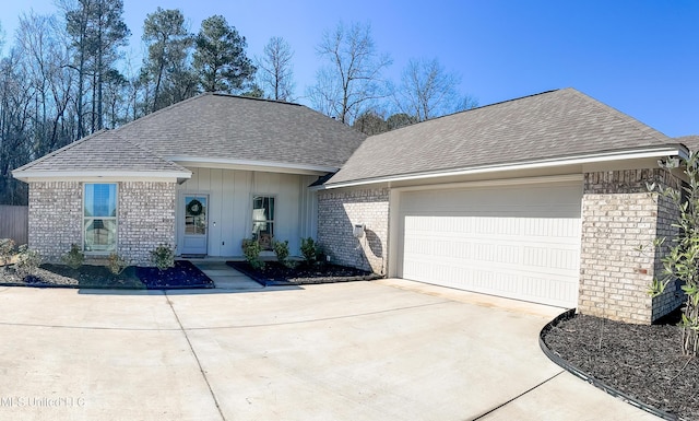 ranch-style home with brick siding, an attached garage, and roof with shingles