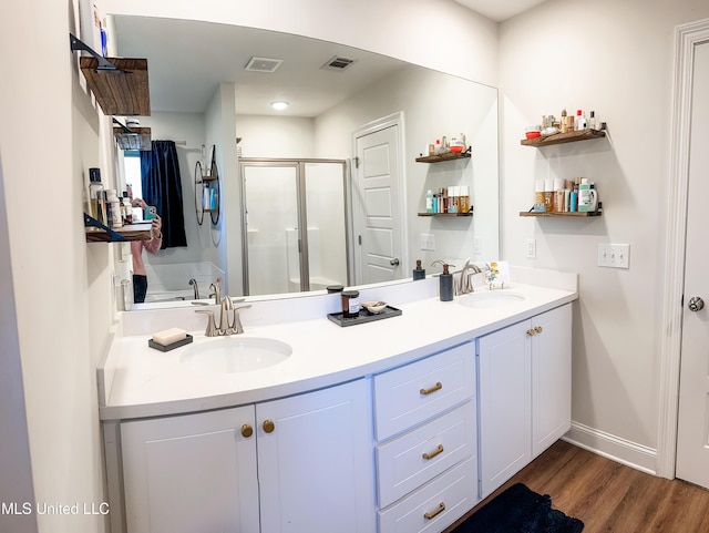 bathroom with a sink, visible vents, and a shower stall